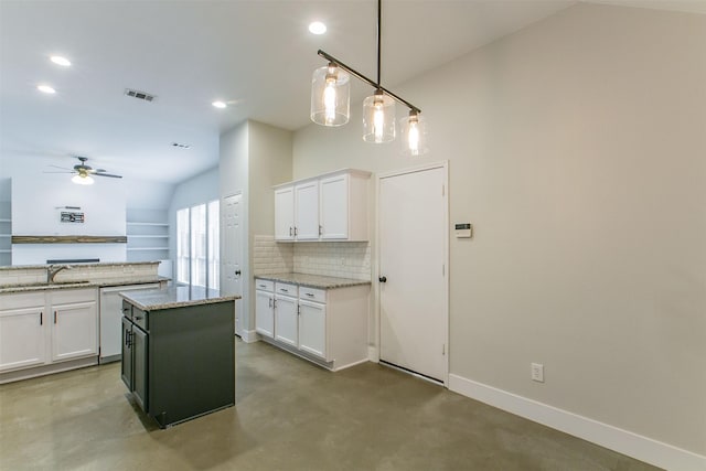 kitchen with white cabinetry, pendant lighting, a kitchen island, and light stone countertops