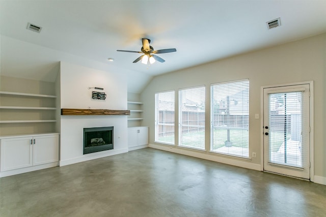 unfurnished living room featuring ceiling fan, built in features, and concrete flooring