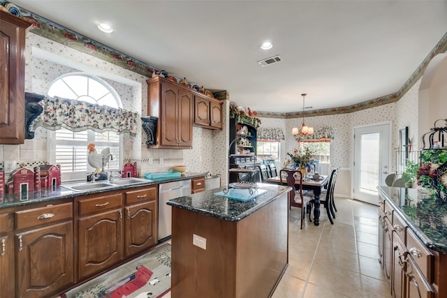 kitchen featuring sink, a center island, an inviting chandelier, stainless steel dishwasher, and light tile patterned floors