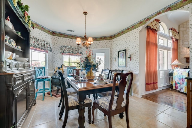 dining room with light tile patterned floors and an inviting chandelier