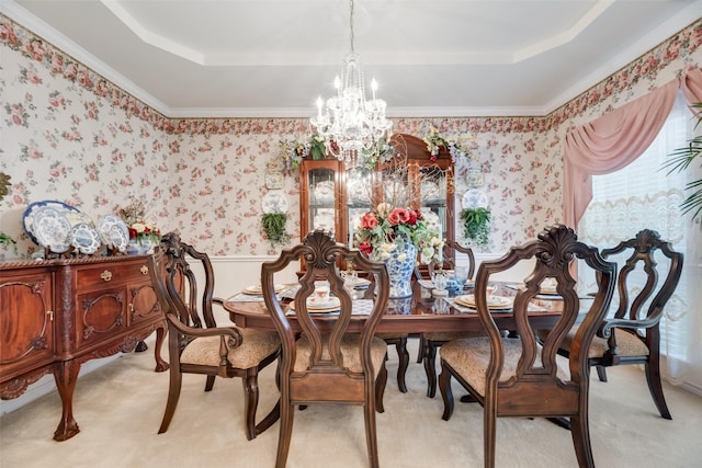 dining room with a tray ceiling, ornamental molding, and an inviting chandelier