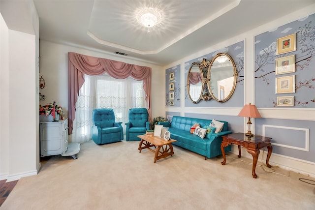 carpeted living room with a raised ceiling