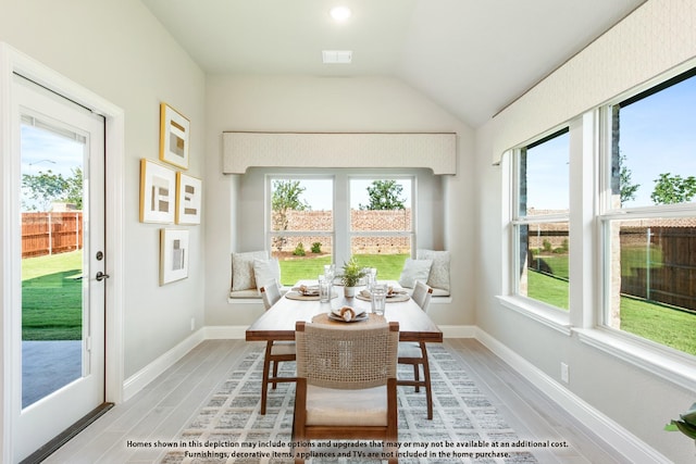 dining area featuring plenty of natural light and vaulted ceiling