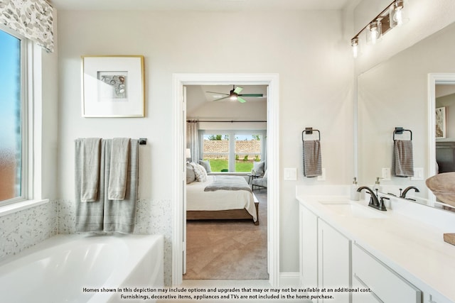 bathroom featuring ceiling fan, a bathtub, and vanity