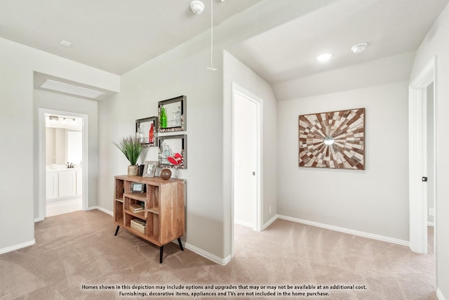 corridor with light colored carpet and lofted ceiling