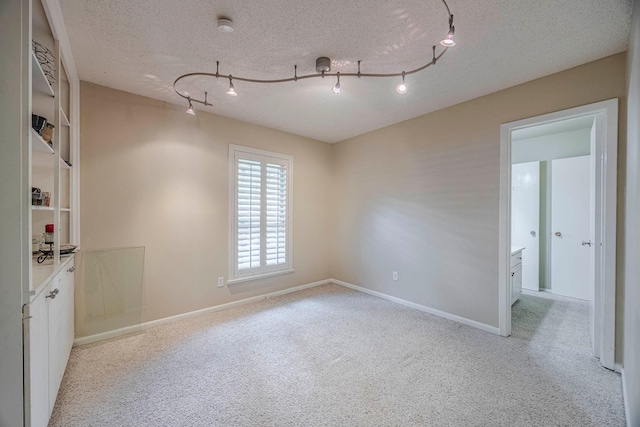 carpeted spare room featuring a textured ceiling