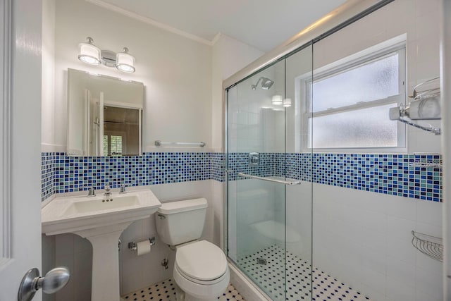 bathroom featuring ornamental molding, plenty of natural light, a shower with shower door, and toilet