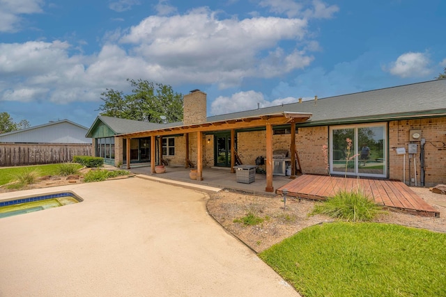 rear view of property featuring a patio area and a deck