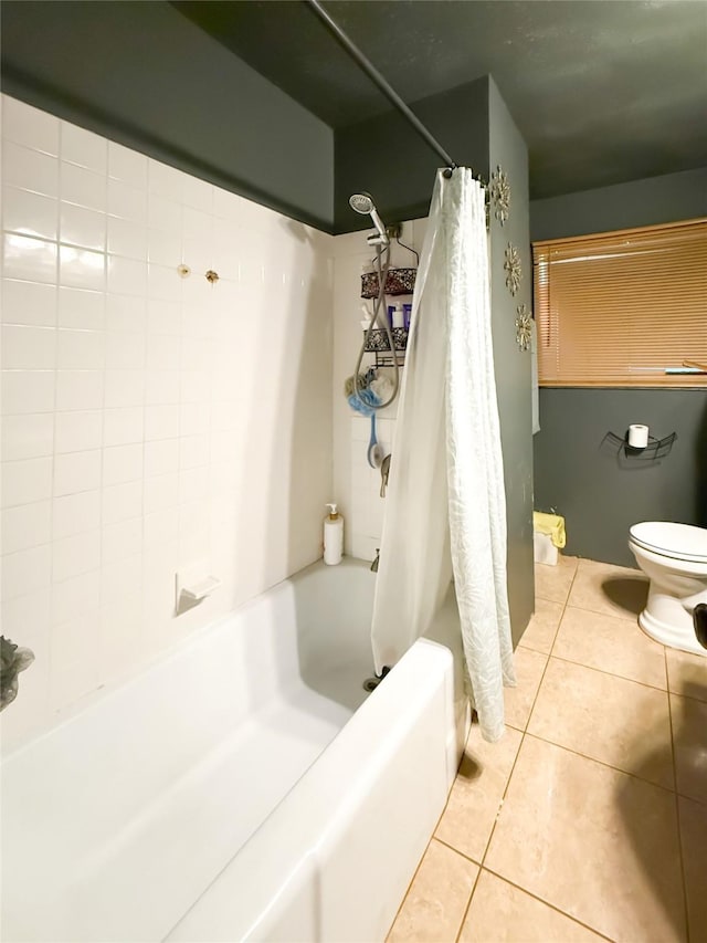 bathroom featuring tile patterned flooring, shower / bath combination with curtain, and toilet