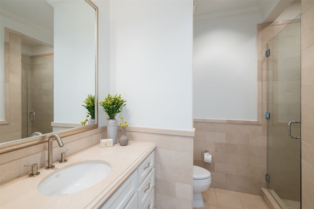 bathroom featuring tile patterned floors, crown molding, toilet, a shower with door, and tile walls