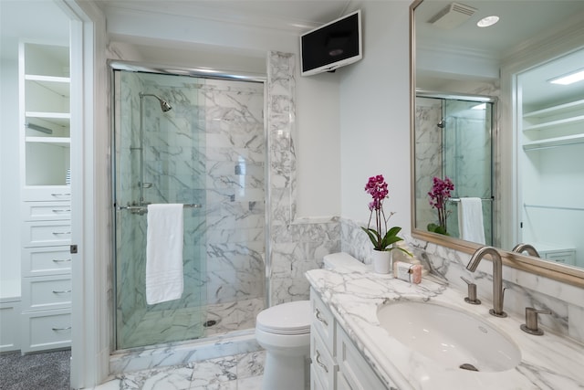 bathroom featuring vanity, toilet, a shower with door, and crown molding