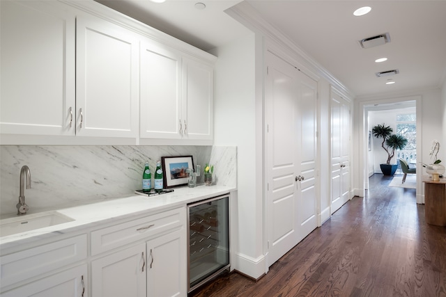 bar with sink, dark wood-type flooring, beverage cooler, tasteful backsplash, and white cabinets