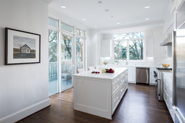 kitchen featuring backsplash, high quality appliances, white cabinets, a center island, and dark hardwood / wood-style floors