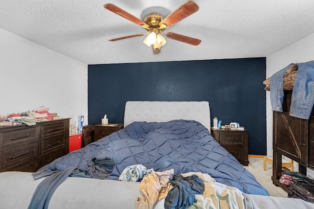 carpeted bedroom featuring a textured ceiling and ceiling fan