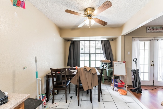 tiled dining area with a wealth of natural light, ceiling fan, and a textured ceiling