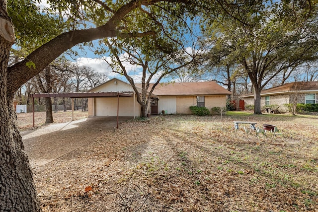 ranch-style home featuring a garage and a carport