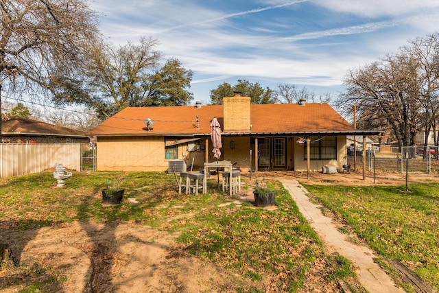 rear view of house with a yard and central AC