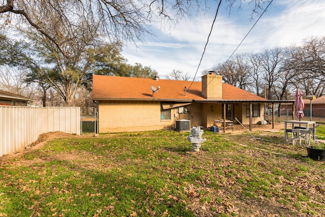 back of house featuring cooling unit and a lawn