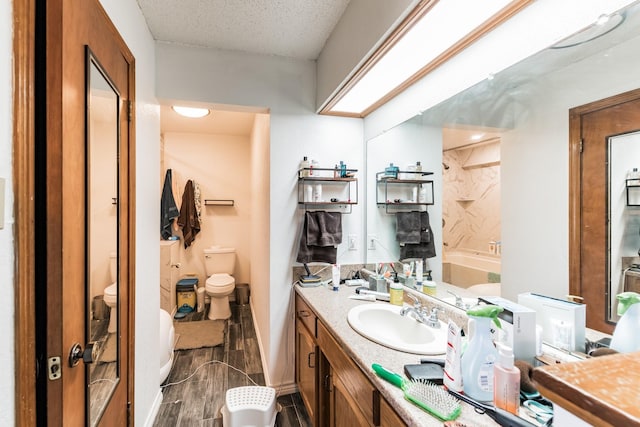 bathroom with vanity, a textured ceiling, and toilet