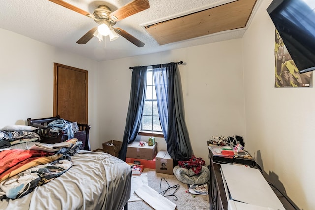 bedroom featuring ceiling fan, light carpet, and a textured ceiling