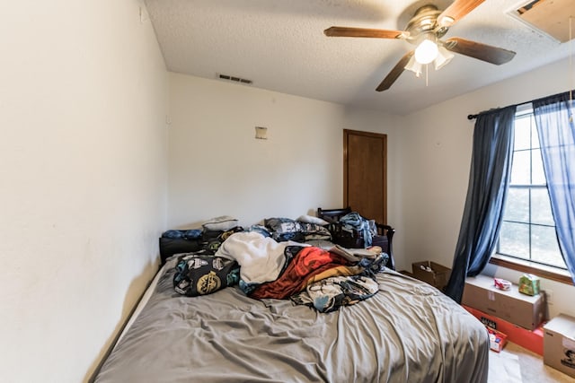 bedroom featuring carpet flooring, a textured ceiling, and ceiling fan