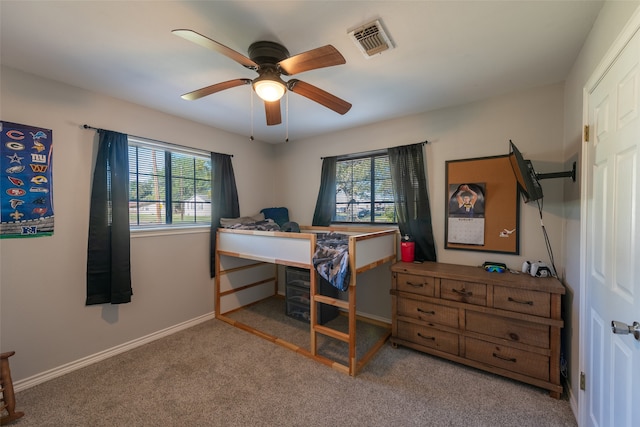 bedroom featuring multiple windows, ceiling fan, and light colored carpet