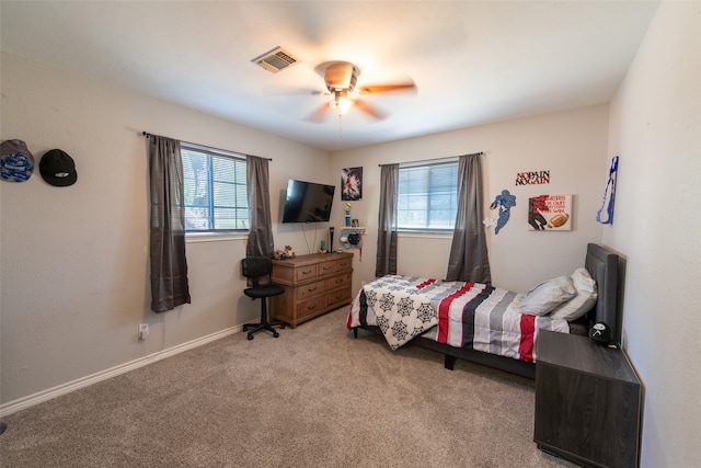 carpeted bedroom with multiple windows and ceiling fan