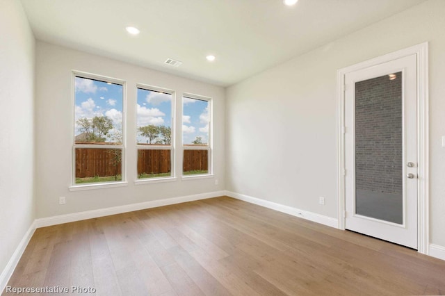 empty room with light hardwood / wood-style flooring