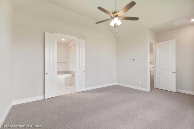 unfurnished bedroom featuring carpet flooring, ceiling fan, lofted ceiling, and connected bathroom