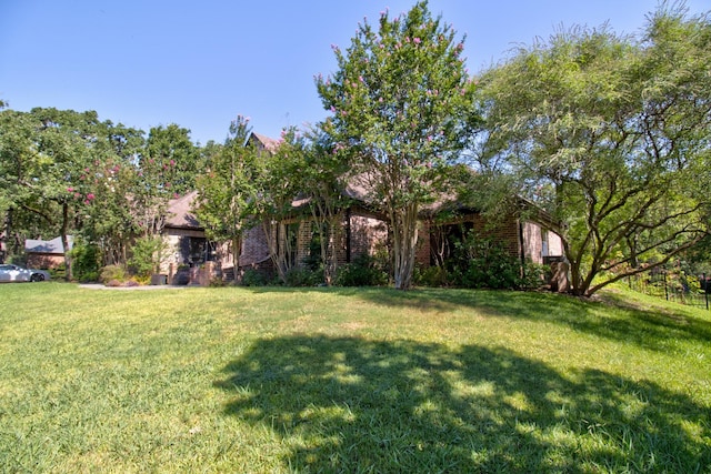 view of property hidden behind natural elements featuring a front yard