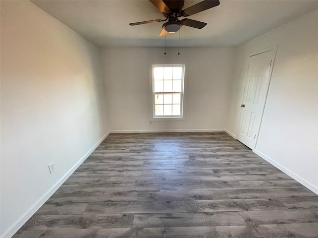 empty room featuring ceiling fan and dark hardwood / wood-style flooring