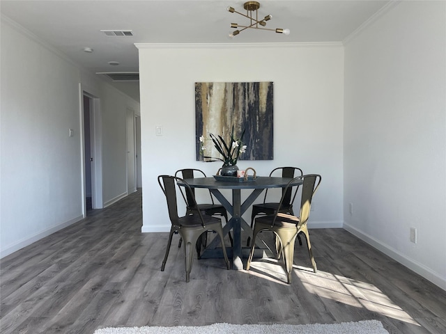 dining space featuring hardwood / wood-style floors, crown molding, and a chandelier