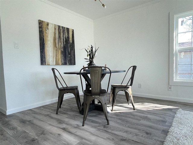 dining space with wood-type flooring and crown molding