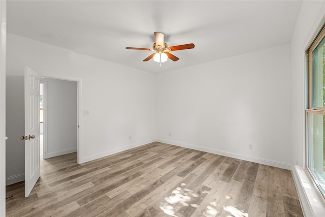 empty room with ceiling fan, a healthy amount of sunlight, and light wood-type flooring