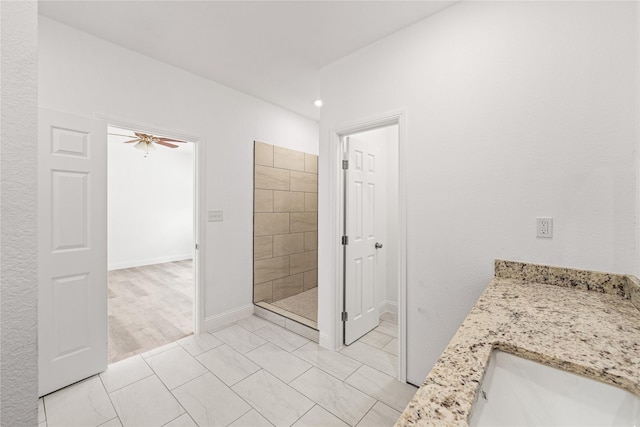 bathroom featuring tile patterned flooring, vanity, tiled shower, and ceiling fan