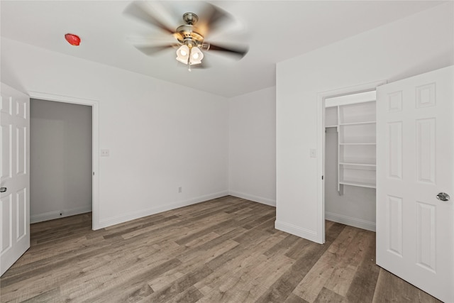 unfurnished bedroom with ceiling fan, light wood-type flooring, and a closet