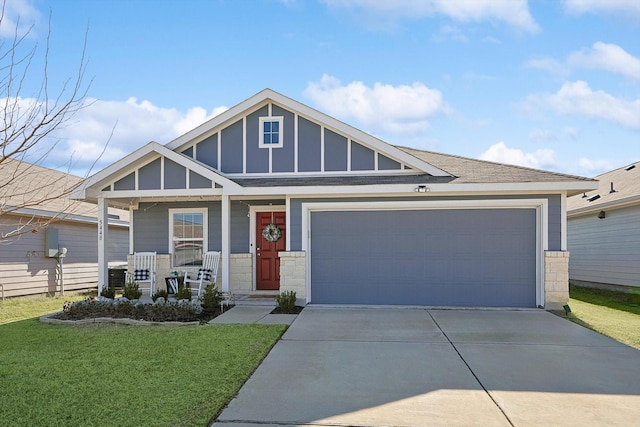 view of front of property with a porch, a garage, and a front yard