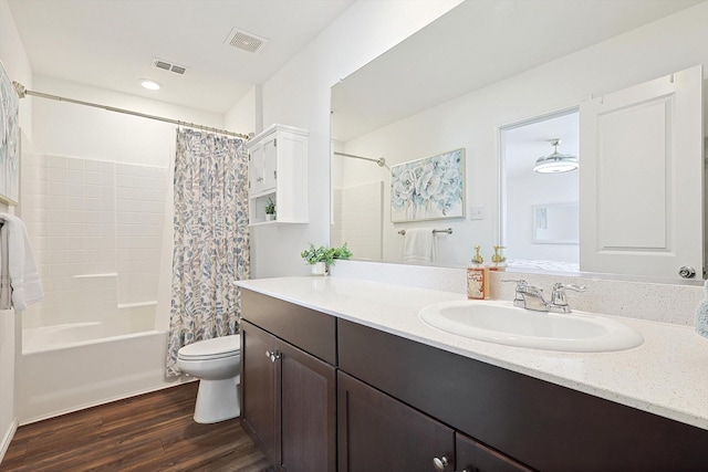 full bathroom with hardwood / wood-style floors, toilet, vanity, and shower / bath combo