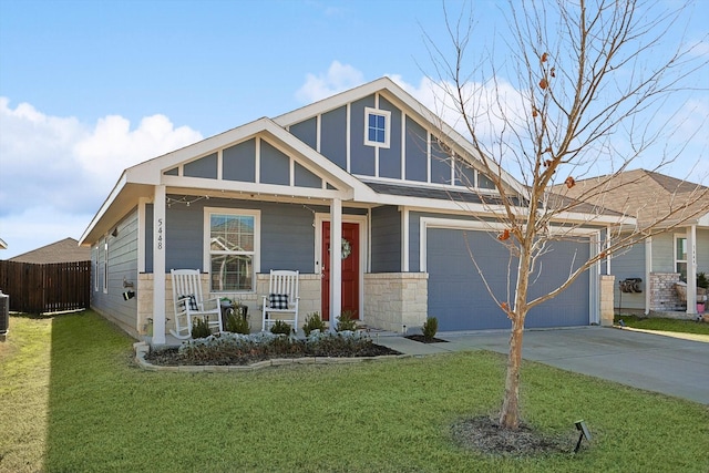 view of front of house with a front yard, covered porch, and a garage