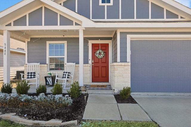 view of exterior entry with a garage and covered porch