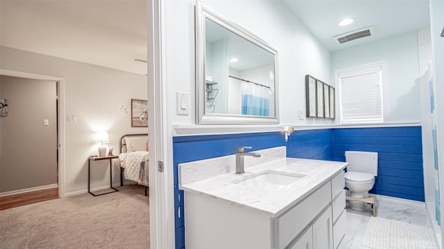 bathroom with toilet, vanity, and curtained shower