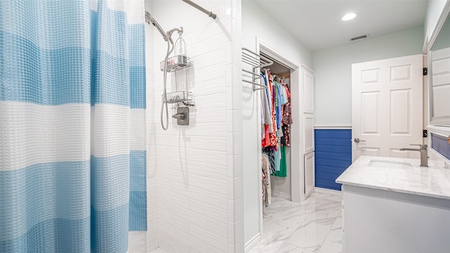 bathroom featuring walk in shower and vanity