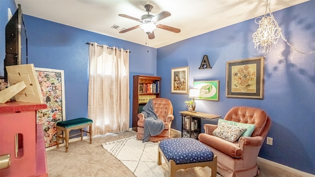 living area featuring ceiling fan and carpet