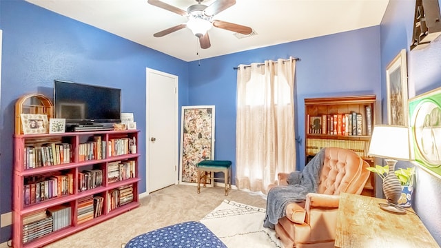 sitting room with ceiling fan and light colored carpet