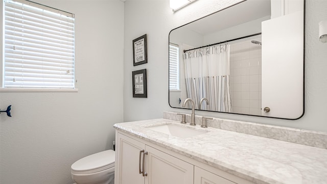 bathroom featuring plenty of natural light, curtained shower, toilet, and vanity