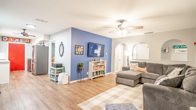 living room featuring ceiling fan and light hardwood / wood-style flooring