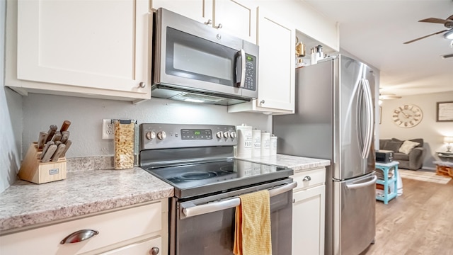 kitchen featuring ceiling fan, appliances with stainless steel finishes, white cabinetry, and light hardwood / wood-style floors