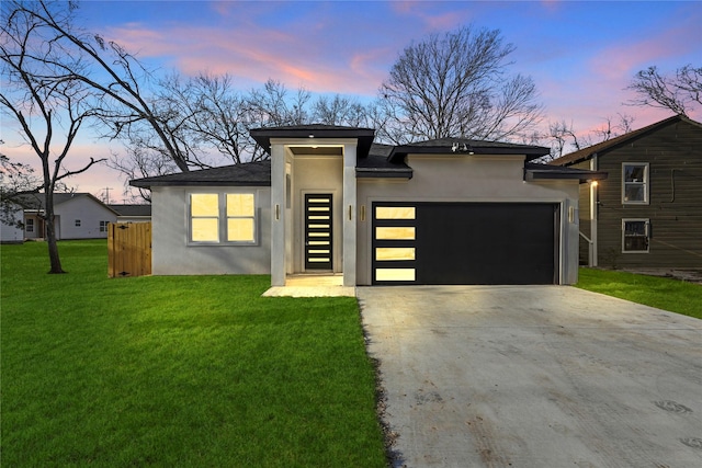 prairie-style home with a yard and a garage