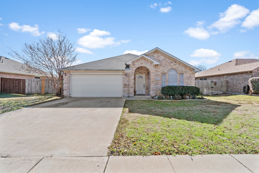 single story home featuring a front yard and a garage