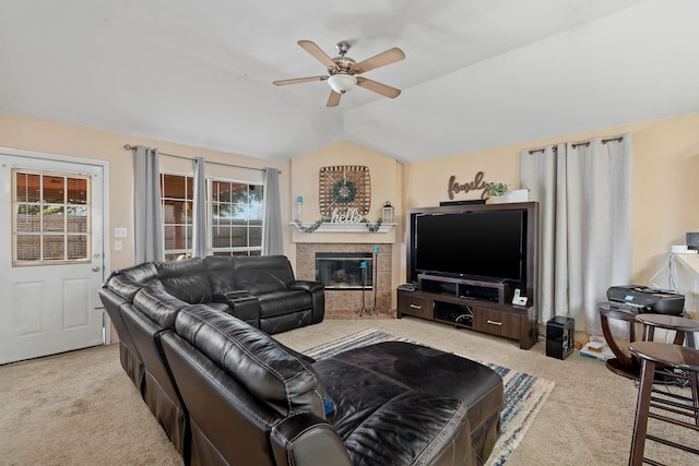 living room featuring a fireplace, light colored carpet, vaulted ceiling, and ceiling fan